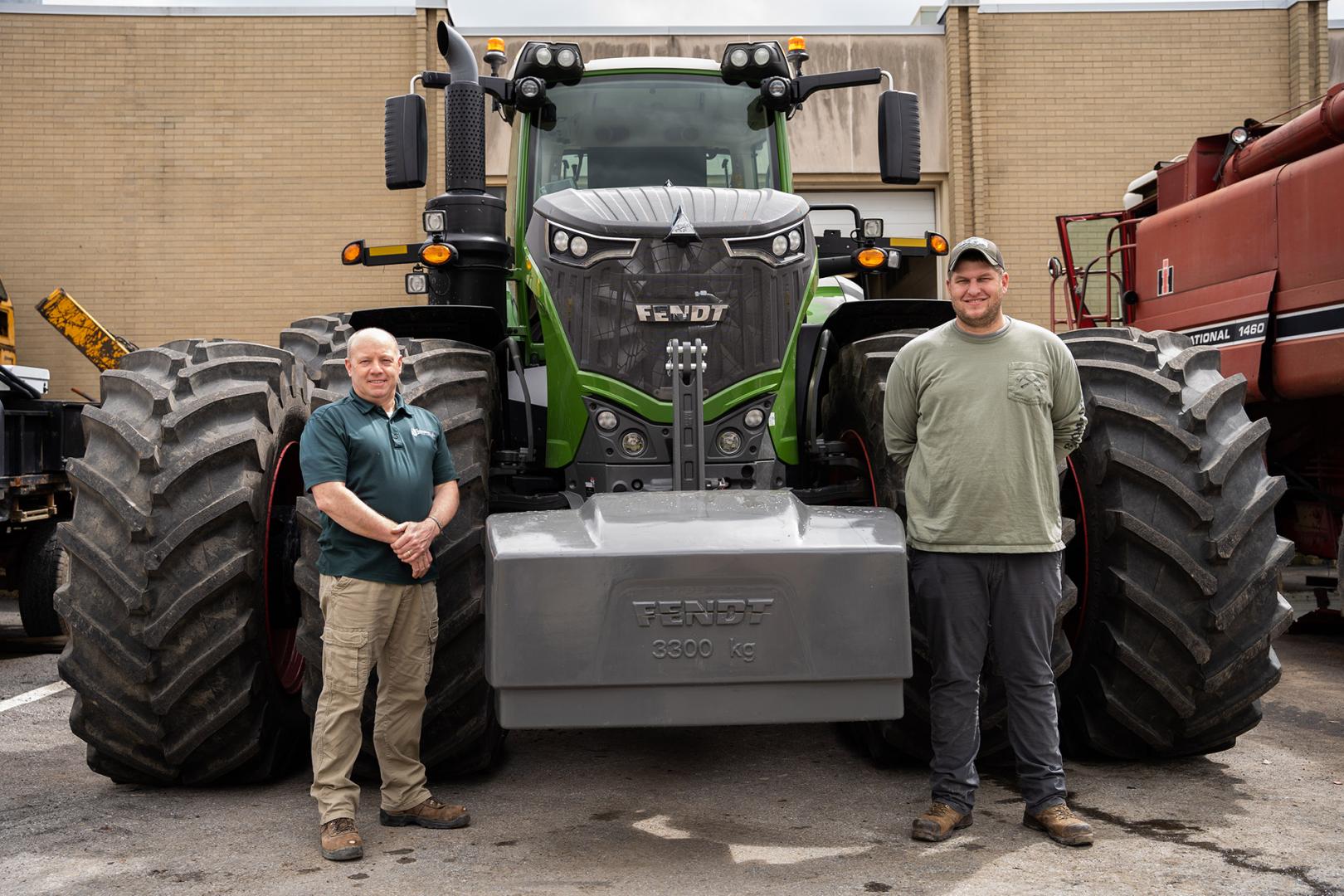 Associate Professor Charles "Chip" Ax ’89, left, and Instructor Jared Ford ’07 of the agricultural engineering and diesel technology programs, stand in front of a tractor students repaired in labs.