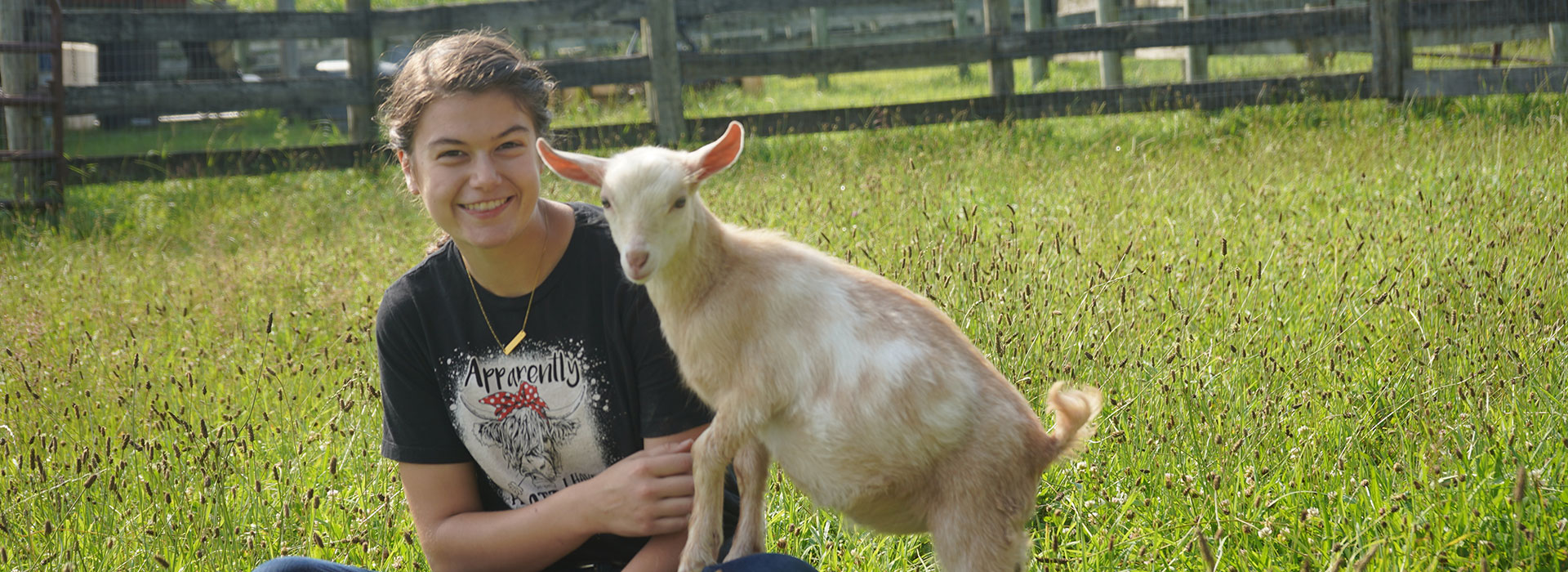 Carrianne Bush and a goat at the SUNY Morrisville livestock barn