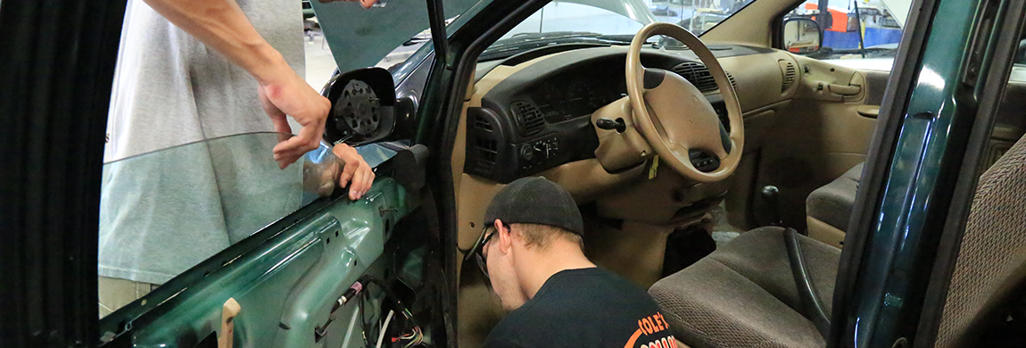 Auto body students working on a car